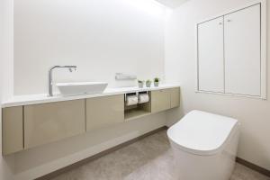 宮島にある宮島コーラルホテルの洗面台とトイレを備えた白いバスルーム