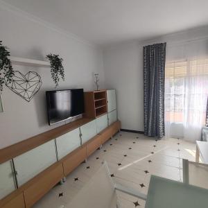 Una sala de estar con un televisor de pantalla plana en una pared. en Casa Álamo, en Puerto Real