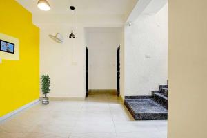 a hallway with yellow and white walls and a potted plant at Hotel O VSV Avenue Hennur in Bengaluru