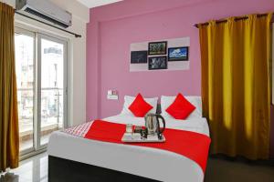 a bedroom with a large bed with red and yellow walls at Hotel O VSV Avenue Hennur in Bengaluru +28 photos