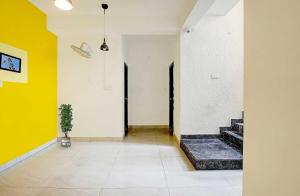 a hallway with yellow and white walls and a potted plant at Hotel O VSV Avenue Hennur in Bengaluru