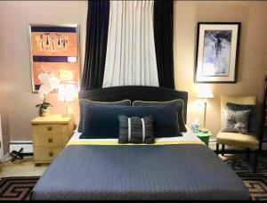 a bedroom with a blue bed and a chair at Grande Lux Room- Boutique Hotel Style-15mins to NYC in Englewood +20 photos
