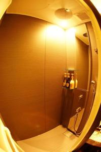 a bathroom with a shower with a round mirror at Hotel Miyoshino Annex in Sano +81 photos