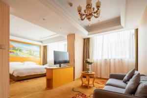 a hotel room with a bed and a couch and a tv at Vienna Hotel Tianjin 5th Avenue Youyi Road Cultural Center Metro Station in Tianjin