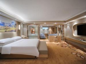 a large bedroom with a large bed and a flat screen tv at Vienna Hotel Shandong Liaocheng High-Tech Zong Yueji Park in Liaocheng
