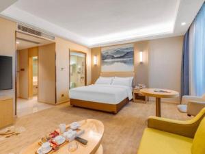 a hotel room with a bed and a living room at Vienna Hotel Baoshan Yongchang Road in Baoshan +137 photos