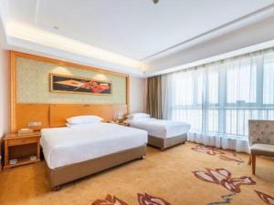 une chambre d'hôtel avec deux lits et une grande fenêtre dans l'établissement Vienna Hotel Nanchang New Grand Hongcheng Market Xianghu 1st Hospital, à Nanchang 175 autres photos