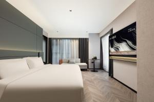 a bedroom with a large white bed in a room at Atour S Hotel Tianshan Road in Shanghai