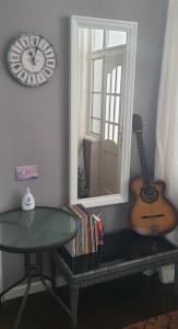 a room with a clock and a guitar and a table at AT Home in Burgas