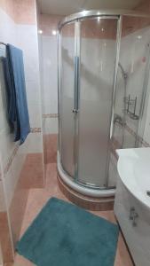 baño con ducha y alfombra azul en AT Home, en Burgas