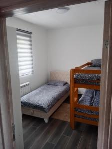 a bedroom with two bunk beds and a window at Nuko's family in Nikšić +23 photos