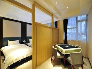 a bedroom with a bed and a desk with aaptop at Super 8 Hotel Guiyang Qianling Park Ruijin North Road in Guiyang
