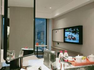 une pièce avec une télévision à écran plat sur un mur dans l'établissement Yinhu Junyi Hotel（Wildlife Park）, à Hangzhou