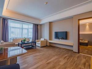 a living room with a couch and a tv at Cheermay Hotels in Dongguan
