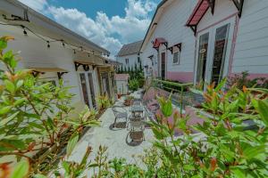 eine Terrasse mit einem Tisch und Stühlen neben einem Gebäude in der Unterkunft Homestay Selena Đà Lạt in Da Lat