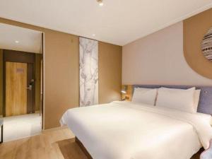 a bedroom with a large white bed and a window at Home Inn Hotel Chengdu Gaoshengqiao Subway Station in Chengdu +86 photos