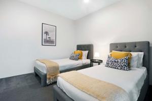 une chambre avec deux lits et une chaise dans l'établissement Circle on Cavill - 2 Bedroom Converted Apartments - Wow Stay - No Parking Included, à Gold Coast 31 autres photos
