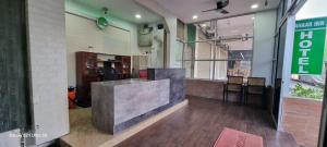 a restaurant with a counter in the middle of a room at Zahaar KN Inn in Batu Ferringhi