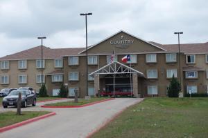 a front view of a hotel with cars parked in a parking lot at Country Inn & Suites by Radisson, Fort Worth West l-30 NAS JRB in Fort Worth