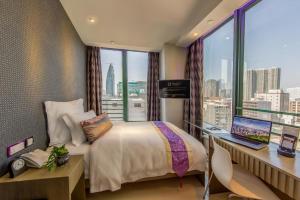香港にあるHarbour Bay Hotelのベッドとパソコン付きの机がある寝室