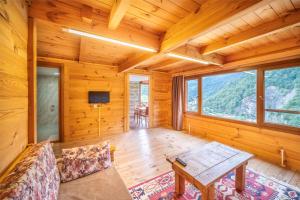 a log cabin living room with a table and a couch at panoramabungalov in Çamlıhemşin