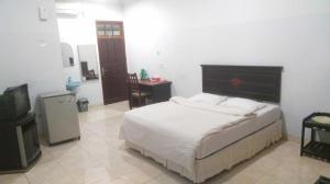 a bedroom with a bed and a television in it at Avicenna Hotel in Palangkaraya