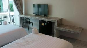 a room with two beds and a tv on a counter at Kosit One Hotel in Ban Bung Sam Phan Nok +178 photos