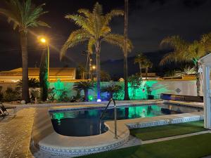 a swimming pool at night with palm trees and lights at Casa Valdi, fantastic 4 bedroom house with private,heated swimming pool and barbecue in Ciudad Quesada +34 photos