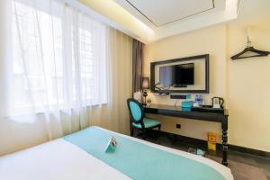 a hotel room with a bed and a desk and a television at Xana Hotelle· Tianjin Railway Station Jinwan Square Binjiang Avenue in Tianjin +212 photos
