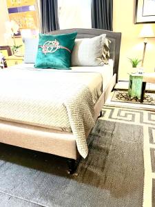 a bed with a green pillow on it in a room at Grande Lux Room- Boutique Hotel Style-15mins to NYC in Englewood