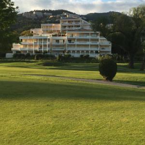 a large white building in front of a green field at Riviera Home in Mandelieu-La Napoule