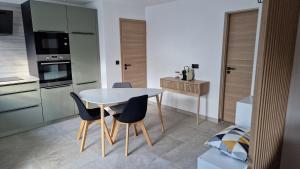 a kitchen with a table and chairs in a room at Agreable T2 proche Crolles coeur Gresivaudan in Villard-Bonnot +2 photos