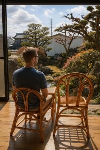 端岛岐阜羽島の隠れ家 古民家cocone的坐在椅子上看窗外的人