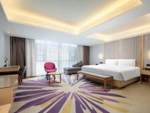 a hotel room with a bed and a pink chair at Lavande Hotel·Wuhan Qingshan Zhongyuan Plaza in Wuhan