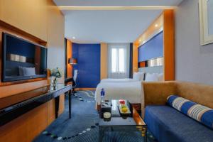 a hotel room with a bed and a couch at Grand Skylight Hotel KaiMei in Nanchang