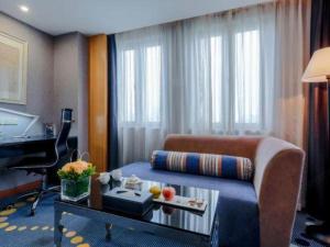 a hotel room with a couch and a piano at Grand Skylight Hotel KaiMei in Nanchang