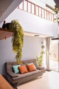 a living room with a couch with a plant on the wall at Casa com vista para o mar e piscina em Milagres in São Miguel dos Milagres