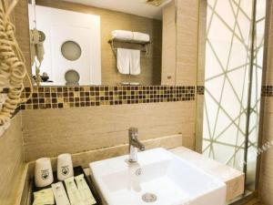 a bathroom with a sink and a mirror and towels at GreenTree Alliance Ningbo Metro South Changshou Road Branch in Ningbo +171 photos