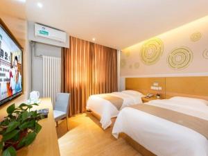 a hotel room with two beds and a flat screen tv at GreenTree Inn Beijing Tonzhou Maju Bridge No.2 Express Hotel in Beijing +208 photos