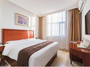 una camera d'albergo con un letto grande e una scrivania di GreenTree Inn Beijing Tonzhou Maju Bridge No.2 Express Hotel a Pechino