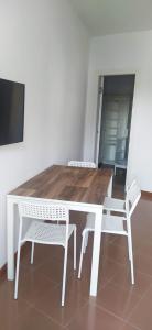 a wooden table with two white chairs and a television at Casa dei gerani in Montegiordano +11 photos