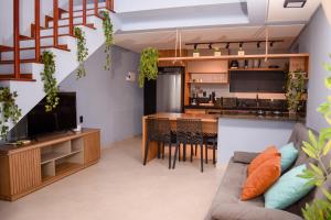 an open living room with a couch and a kitchen at Casa com vista para o mar e piscina em Milagres in São Miguel dos Milagres