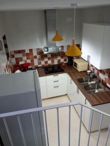 a kitchen with white cabinets and a sink and a refrigerator at Alojamiento Rural Los Jarritos in Galaroza