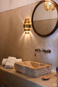 a bathroom with a stone sink and a mirror at Riad Bacha Beldi in Marrakech