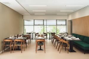 un restaurant avec des tables, des chaises et un canapé vert dans l'établissement Akademis - Fit Split, à Split 43 autres photos