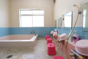 a bathroom with a pink tub and a sink at Greenchair AMANO in Yamanakako
