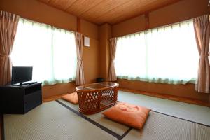 a living room with a room with windows and a tv at Greenchair AMANO in Yamanakako