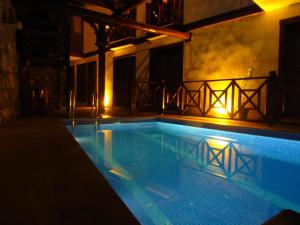 a swimming pool in a building at night at Amazon Petite Palace in Selçuk