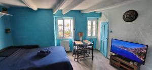 a bedroom with a bed and a flat screen tv at Spectacular Seaview & Sunset Studio in Old Town in Menton