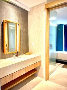 a bathroom with a sink and a mirror and a shower at Truntum Boutique Mandalika in Kuta Lombok